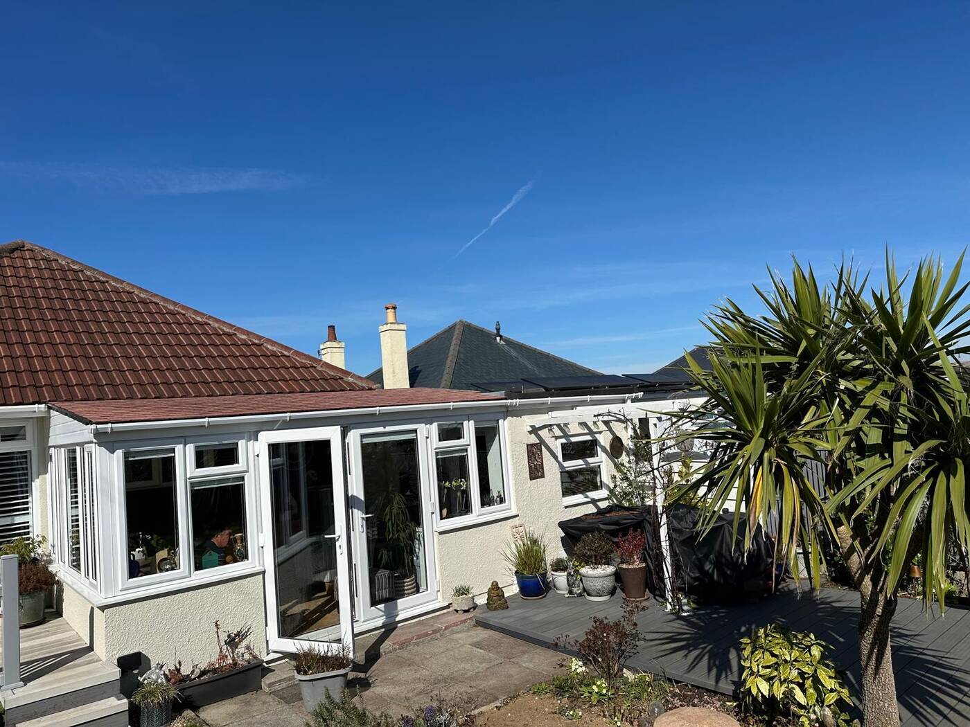 Insulated tiled conservatory roof on a bungalow with terracotta tiles