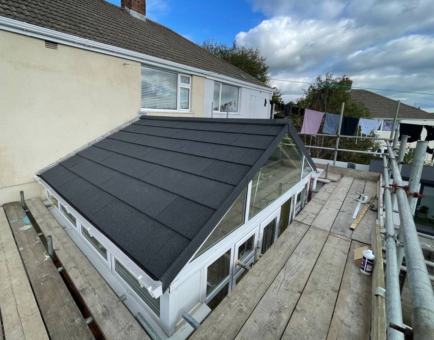 Conservatory roof replacement in Devon with white frame and dark grey tiled finish